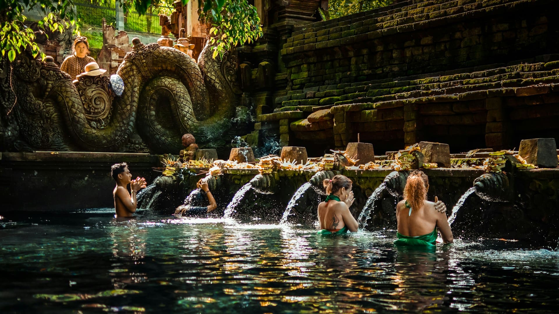 Travelers participating in a traditional water purification ritual at Tirta Empul during a Bali Spiritual Trip.